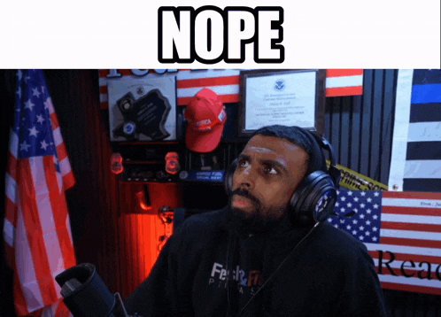 a man wearing headphones stands in front of a microphone with the word nope above him
