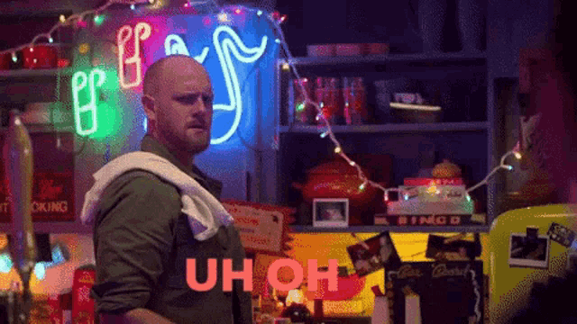 a man standing in front of a neon sign that says " uh oh "