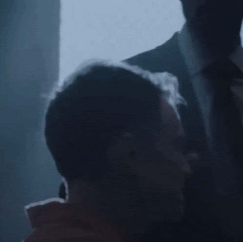 a man in a suit is standing next to another man