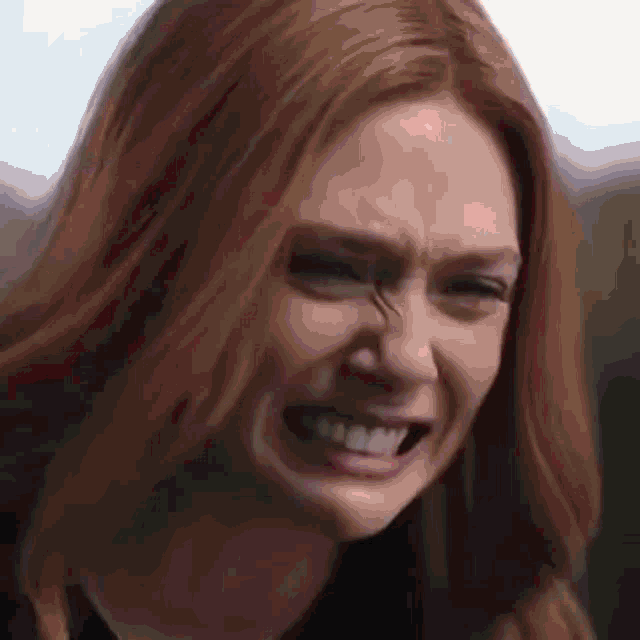 a close up of a woman with red hair making a funny face