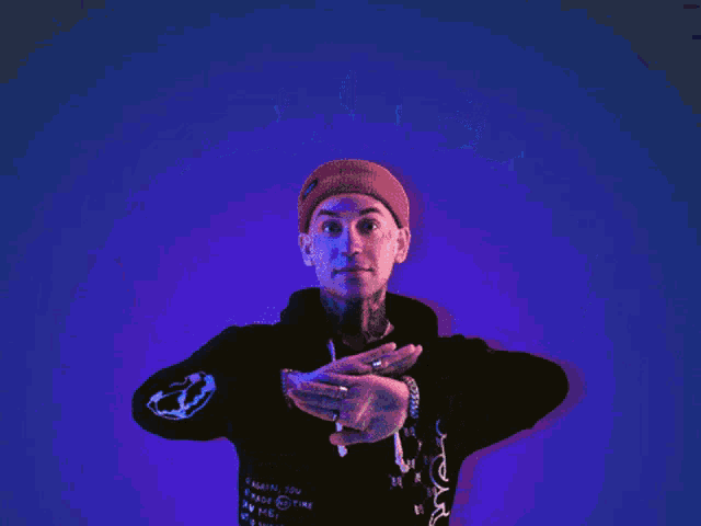 a man holds up his hands in front of a neon sign that says anxiety