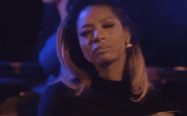 a woman in a black dress is smiling in a club .