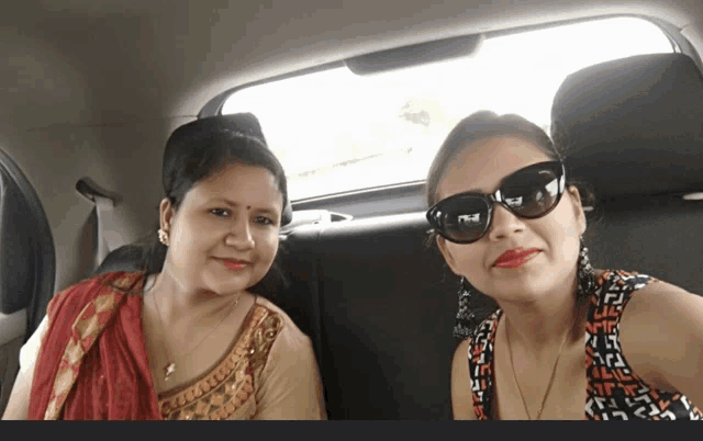 two women are posing for a picture in a car