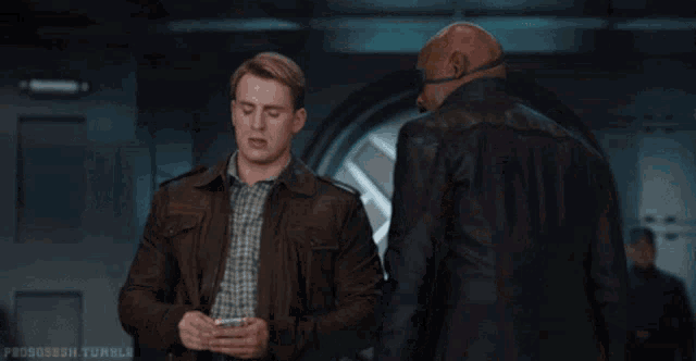 a man in a leather jacket is giving another man money