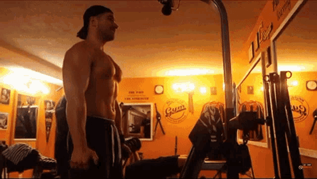 a man stands in a gym with a sign on the wall that says gym