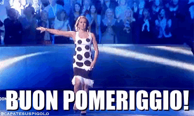 a woman in a polka dot dress is dancing in front of a crowd with the words buon pomeriggio written below her