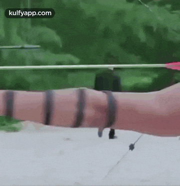a person is holding a bow and arrow in their hand with a green background .