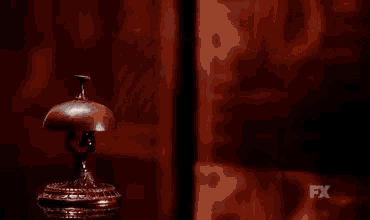 a close up of a person 's hand pressing a hotel bell .
