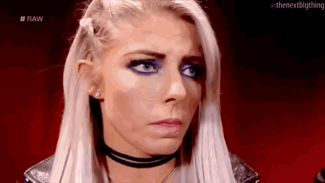 a woman with blonde hair and purple eye shadow is wearing a choker and a leather jacket .