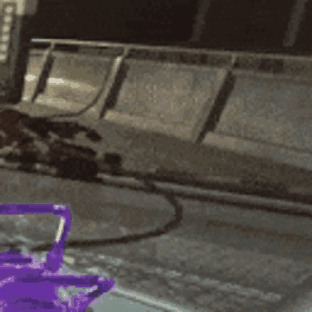 a purple object is sitting on a table in front of a concrete wall