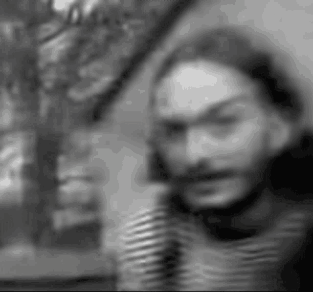 a blurry black and white photo of a man 's face