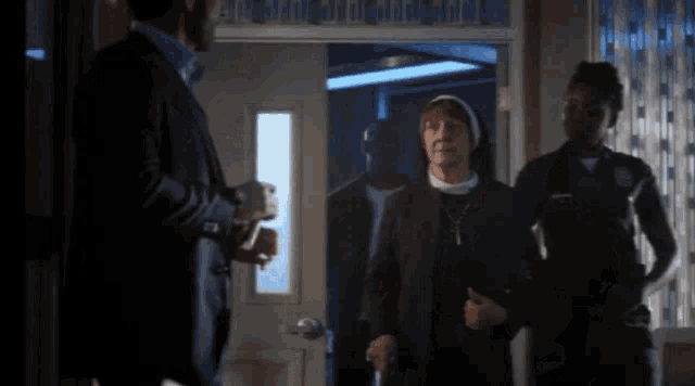 a woman in a nun 's habit is standing in front of a man in a suit