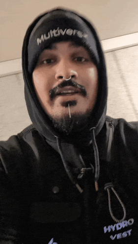 a man wearing a hooded jacket and a hydro vest takes a selfie