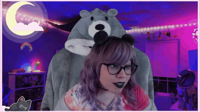 a woman wearing glasses and a bear costume looks at the camera