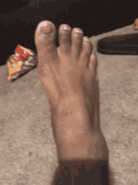 a woman 's foot with pink nail polish on the toe