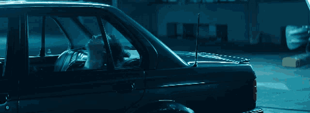 a man sitting in a car with a antenna on the roof