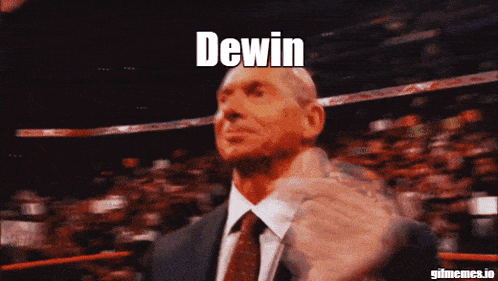 a man in a suit and tie applauds in front of a crowd with the word dewin on the bottom