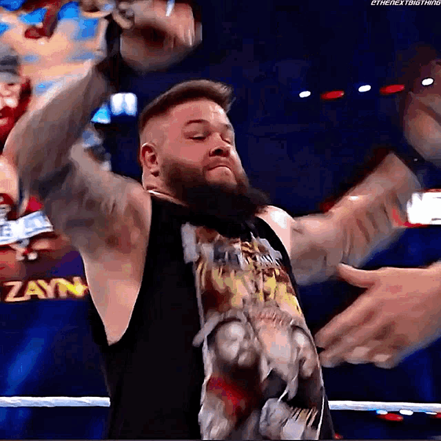 a man with a beard is in a wrestling ring with his arms outstretched
