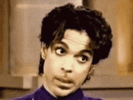 a close up of a man 's face with a purple shirt on .