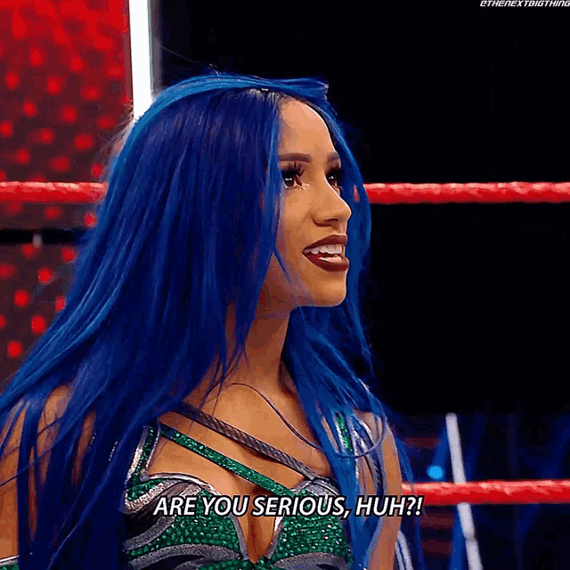 a woman with blue hair is in a wrestling ring and says " are you serious huh "