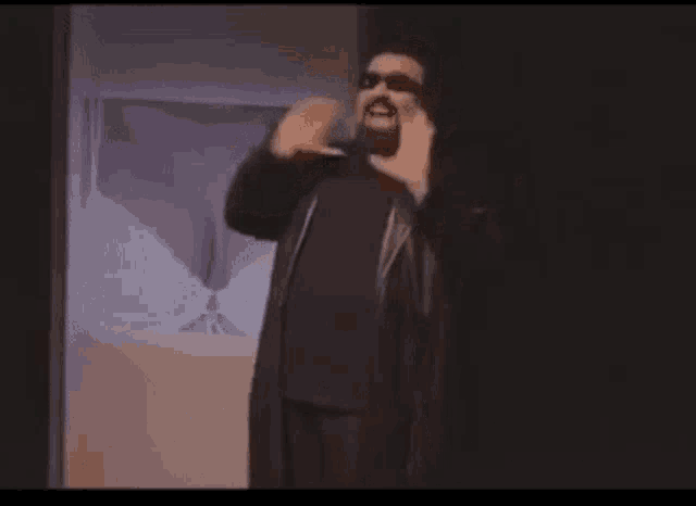 a man with his arms outstretched is standing in front of a screen that says esticazzi