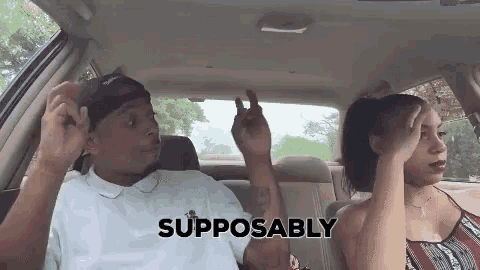 a man and a woman are sitting in the back seat of a car and making funny faces .
