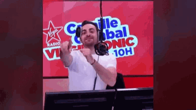 a man wearing headphones in front of a virgin radio logo