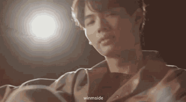 a close up of a person 's face with a light shining on him .