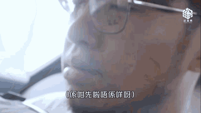 a man with glasses and a beard is talking in chinese