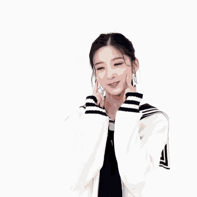 a girl in a sailor suit is making a funny face while holding her hands to her face .
