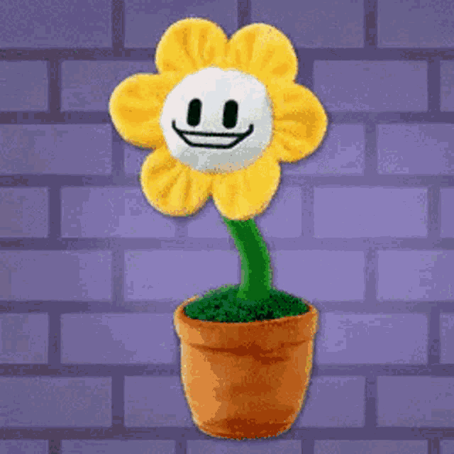 a stuffed flower with a smiling face is in a pot .