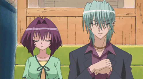 a man with green hair and a woman with purple hair are sitting next to each other with their eyes closed