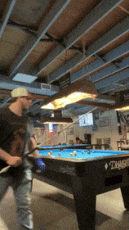 a man is playing pool in a room with a pool table that says ' diamonds ' on it