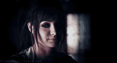 a close up of a woman 's face in the dark with a blurry background .
