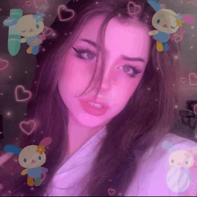 a girl is taking a selfie in front of a pink background with stuffed animals and hearts