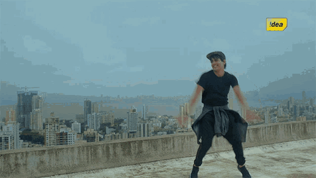 a man is dancing on a rooftop with a yellow sign that says idea in the background