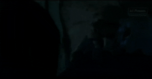 a man is standing in a dark room with a lamp and a window .