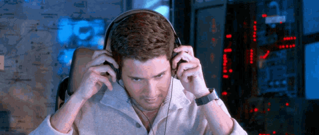 a man wearing headphones looks at the camera with a map in the background