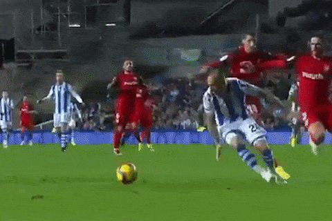 a soccer player in a blue and white uniform is kicking a soccer ball .