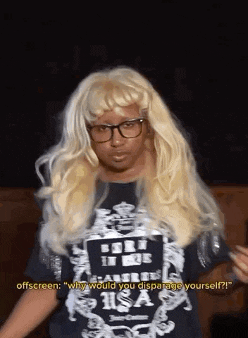 a man in a wig and glasses is wearing a black shirt that says why would you disparage yourself ?