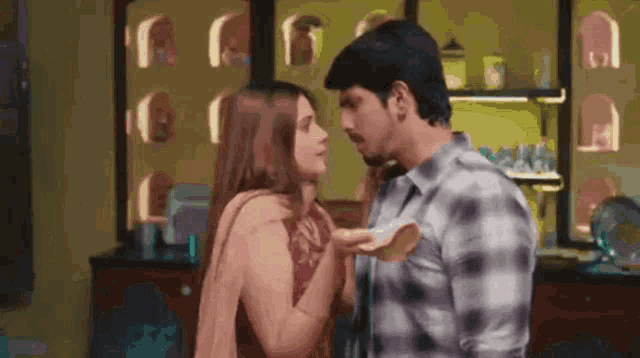 a man and a woman are standing next to each other and kissing .