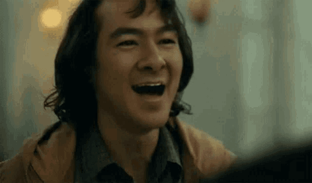 a close up of a man laughing with his mouth open in a joker movie .