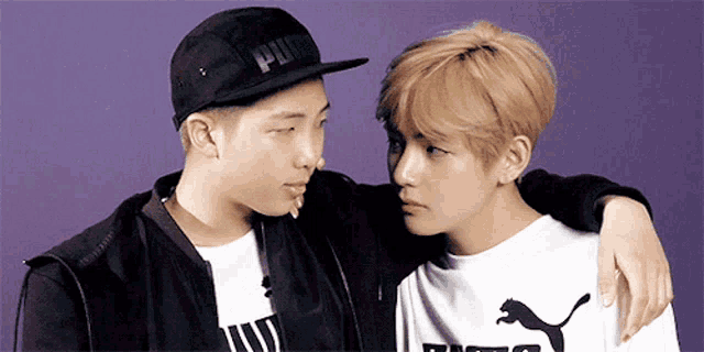 two young men are standing next to each other and one of them is wearing a hat that says puma .