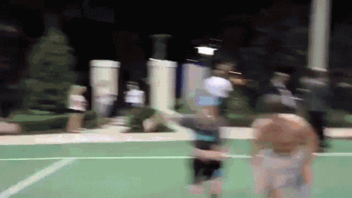 a blurry picture of people playing a game of basketball