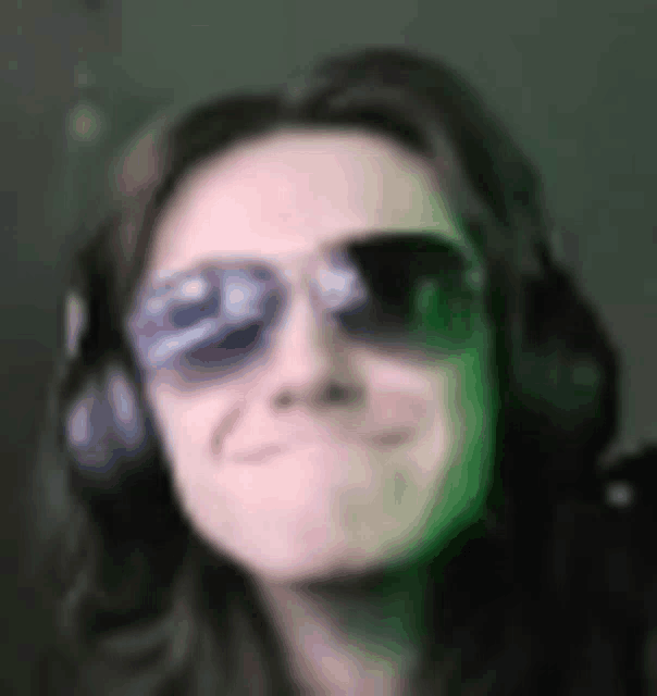 a man wearing sunglasses and headphones is making a face .