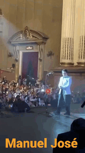 a poster for manuel jose shows a man standing on a stage