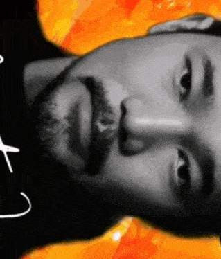 a man with a beard is wearing a black shirt with the letter t on it