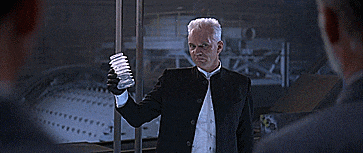a man in a suit is holding a glass and says " lovely "