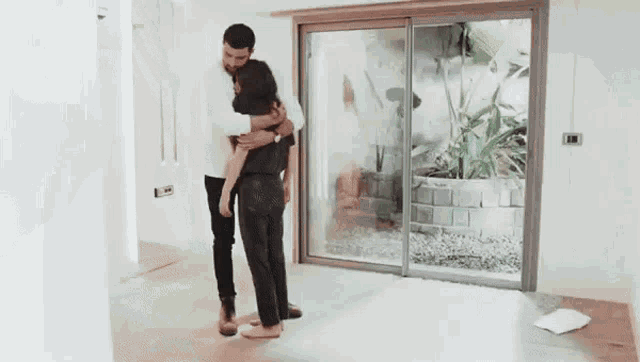 a man with a beard is hugging a woman and looking at her .