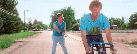 a man in a blue shirt pulls another man on a leash